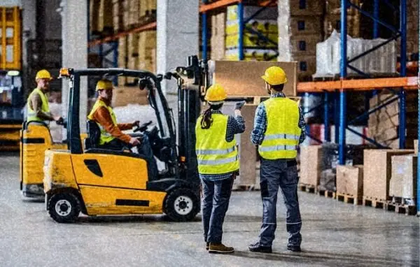 Workers supervising forklift operations in a distribution center | Serious on-the-job injuries.
