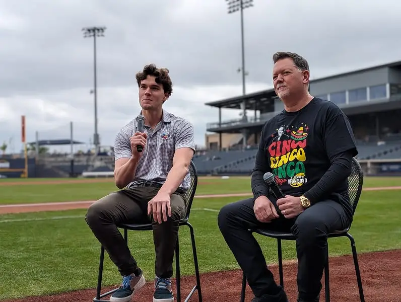 Attorney Dean Boyd and young man speaking at a Cinco de Mayo celebration at a baseball stadium.